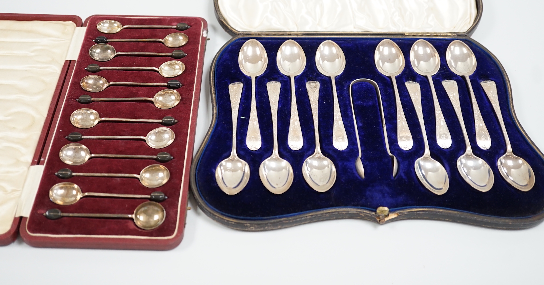 A cased set of twelve Edwardian Scottish silver teaspoons with sugar tongs, Lawson & Co, Glasgow, 1904 and a cased set of twelve sterling bean end coffee spoons, by Alexander Clark Co. Shanghai.